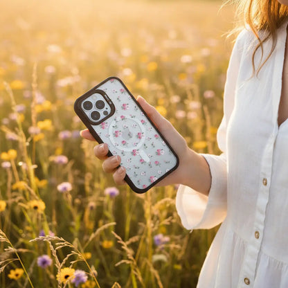 Person holding a phone with a floral case in a field of flowers